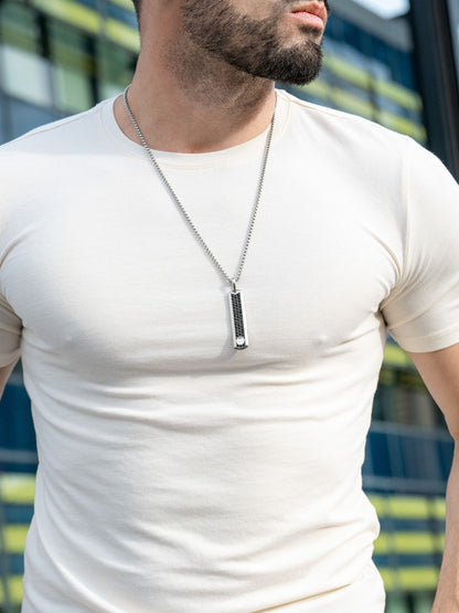 Silver pendant necklace on man: black-studded rectangular pendant on chain