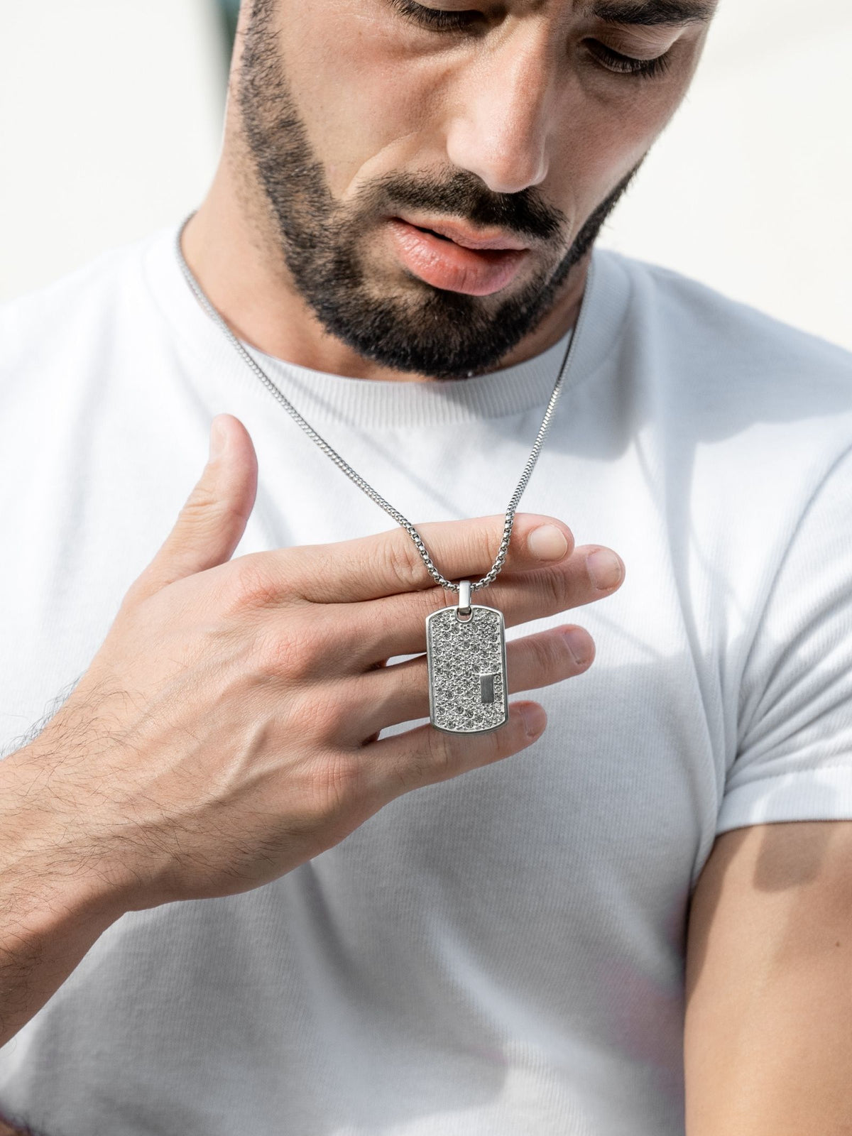 Silver-tone dog tag pendant necklace on a model, clear stone front and chain