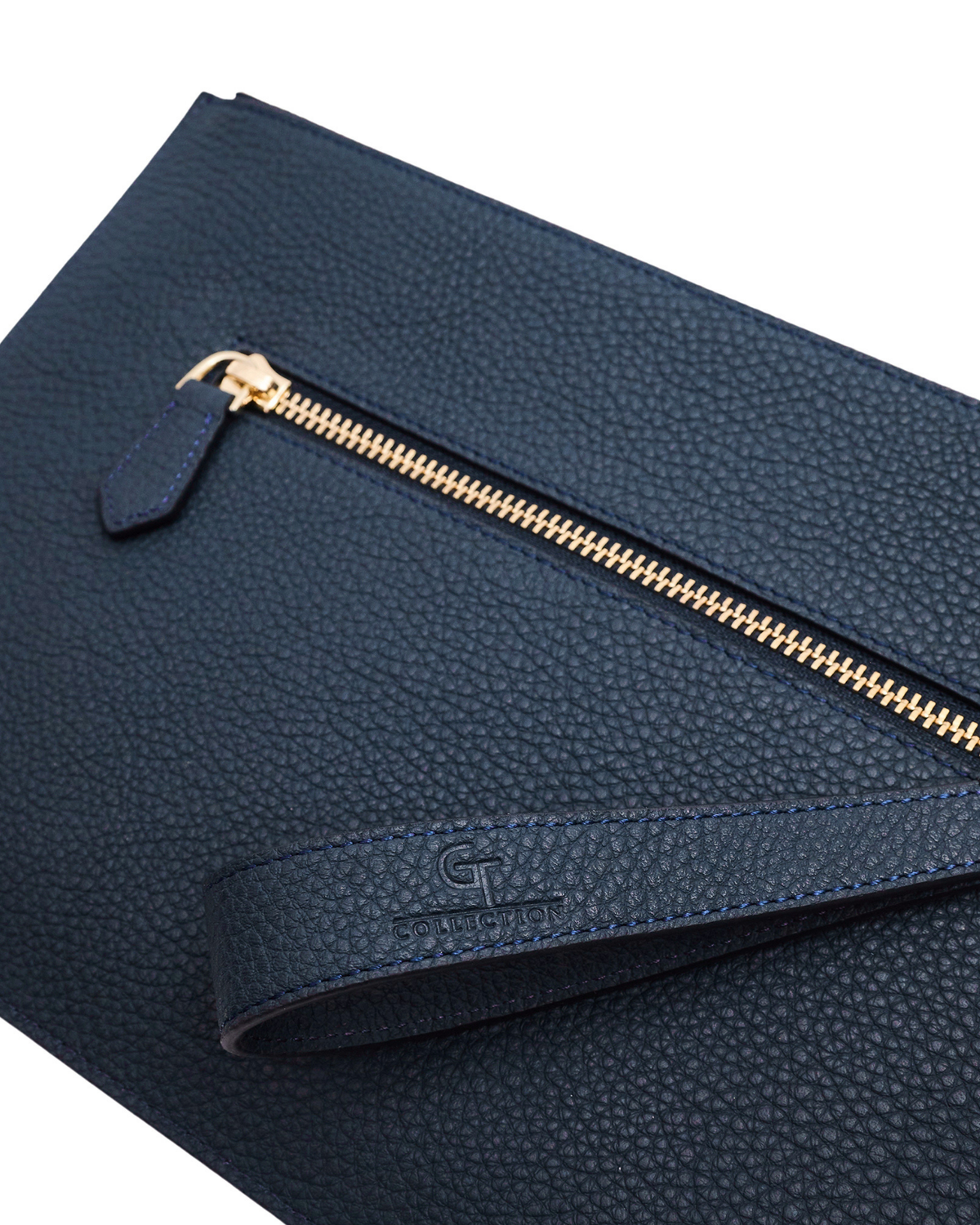 Blue leather pouch close-up with gold zipper, pull tab, and logo patch on flap.