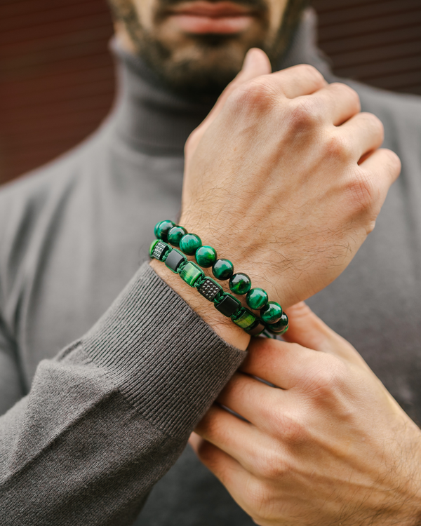 Green bead bracelet on wrist with stacked dark-green beads and black cord