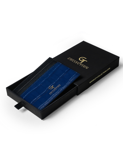Blue croc-embossed leather card holder with black trim and front logo.