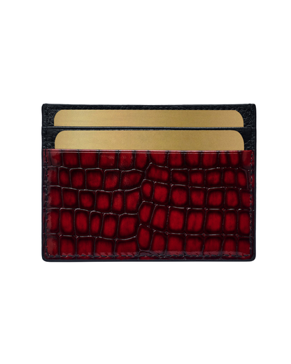Red croc-embossed leather card holder with black trim and gold logo, front view.