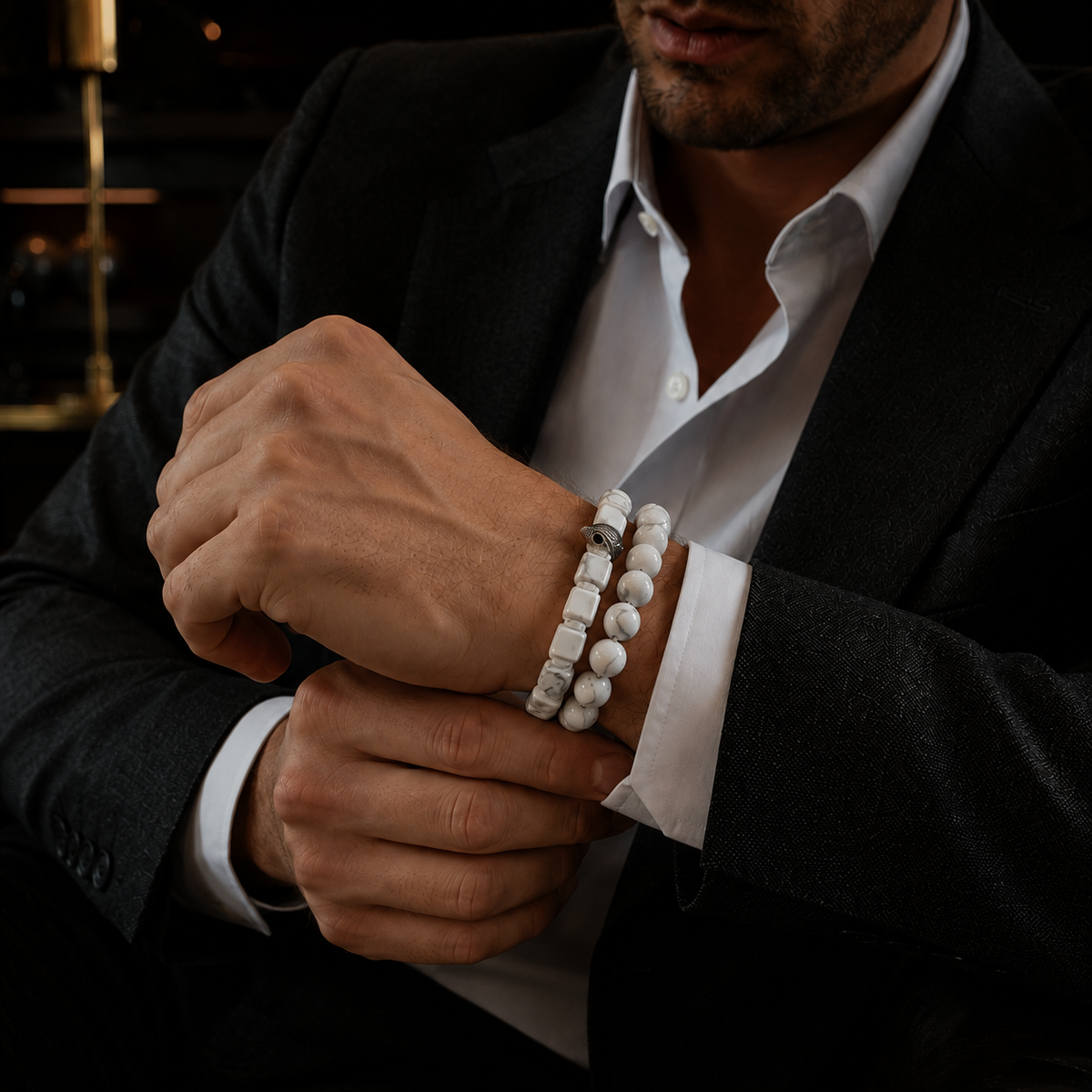 Men's white howlite bracelet stack with silver eagle charms worn on wrist