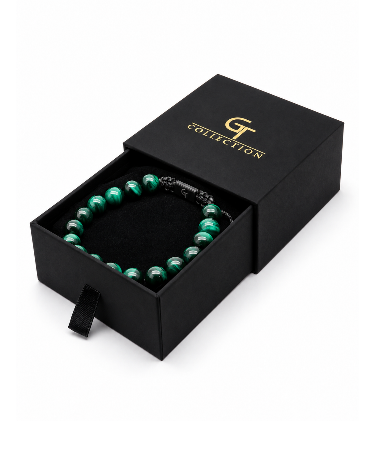 Green and dark bead bracelet resting in a black gift box
