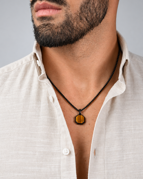 Black chain necklace with octagonal amber tiger-eye pendant worn under shirt collar