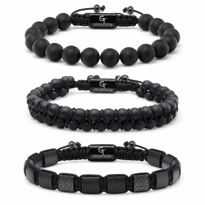 Three black bracelets: matte bead, braided cord, and leather strap with studs