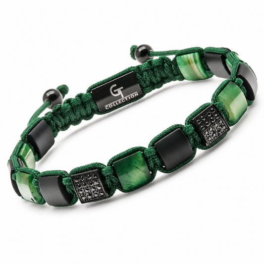 Flat lay of green and black beaded bracelet with cord and metal charms