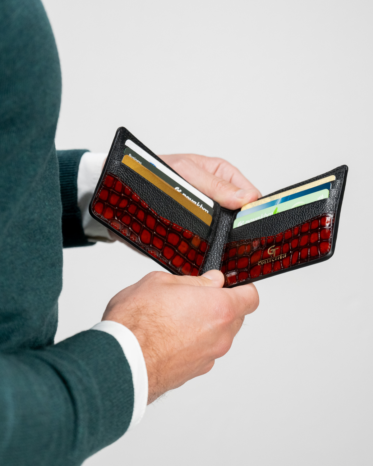 Red croc-embossed leather wallet open, showing card slots and interior pockets.